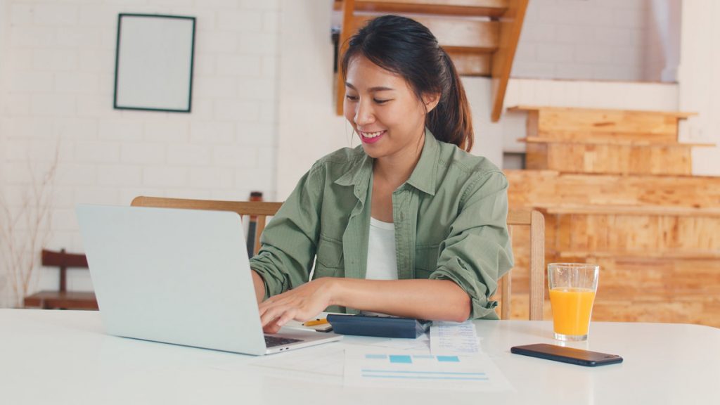 Business asian women records of income and expenses at home.