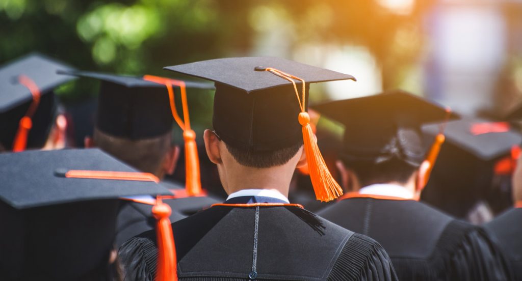 Rear view of graduates join the graduation ceremony at the university.