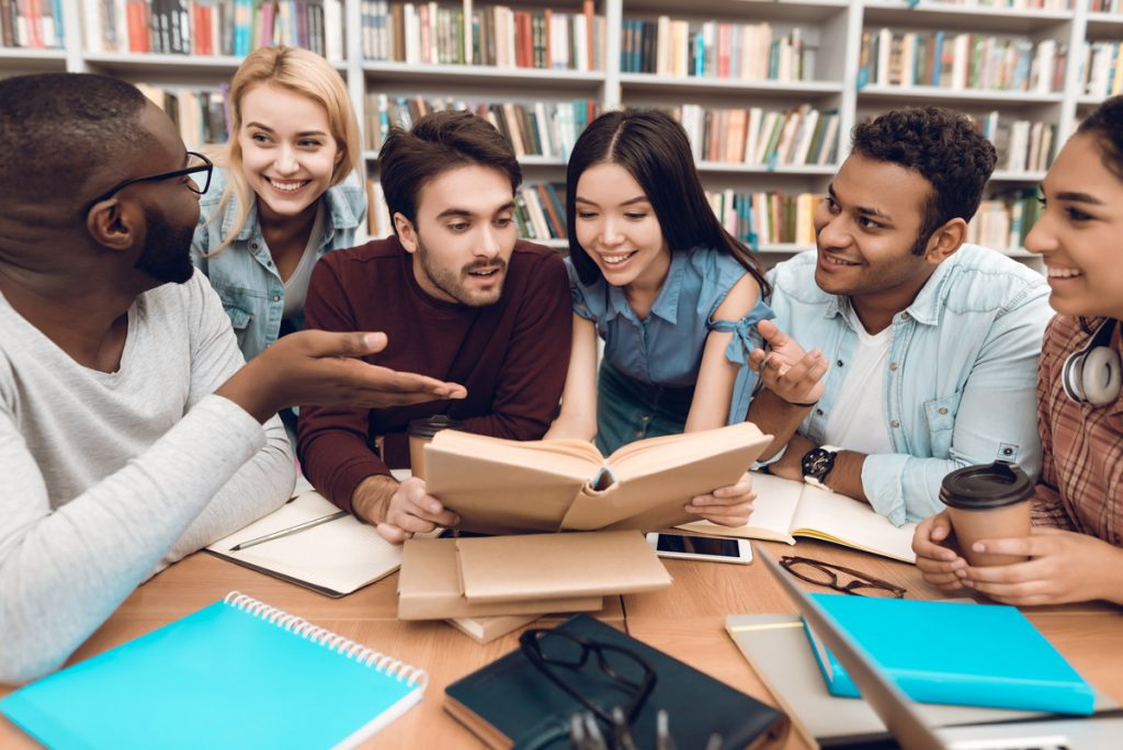 Students discussing studying in library.