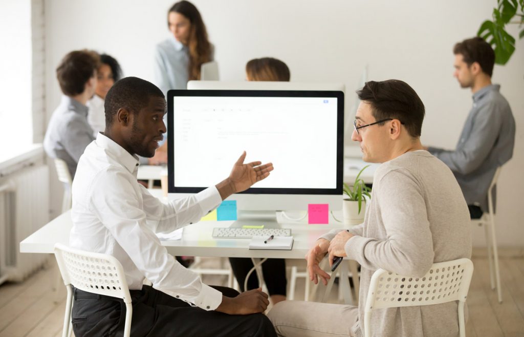 Serious multiracial colleagues having discussion brainstorming project together in office.