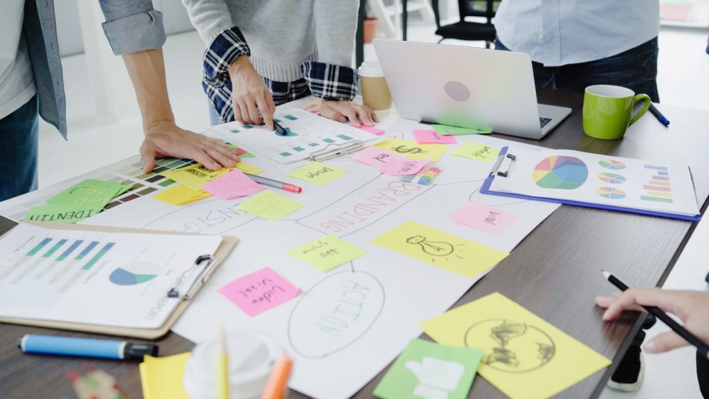 Group of casually dressed business people discussing ideas in the office. Creative professionals gathered at the meeting table for discuss the important issues of the new successful startup project.