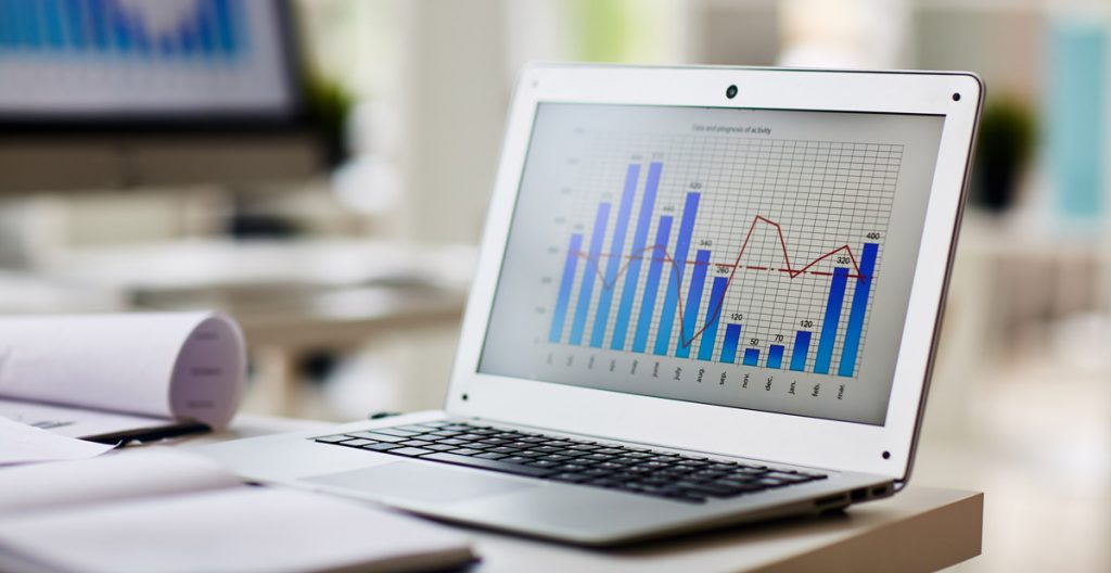 Laptop with chart on its display at workplace of economist.